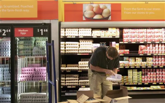 A worker checks for broken eggs April 29 as he stocks the shelves in a Walmart store in Maumelle, Ark. Wal-Mart Stores Inc. plans to significantly ramp up its donations to the nation's food banks to total $2 billion over the next five years.
